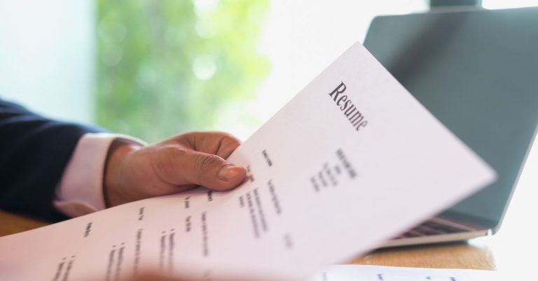 Businessman reviewing a resume, representing professional recruitment services and tips to improve resumes