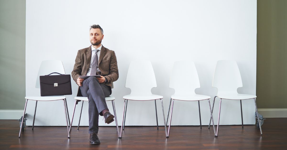 Candidate waiting in a reception area for a job interview, holding a resume and looking prepared.